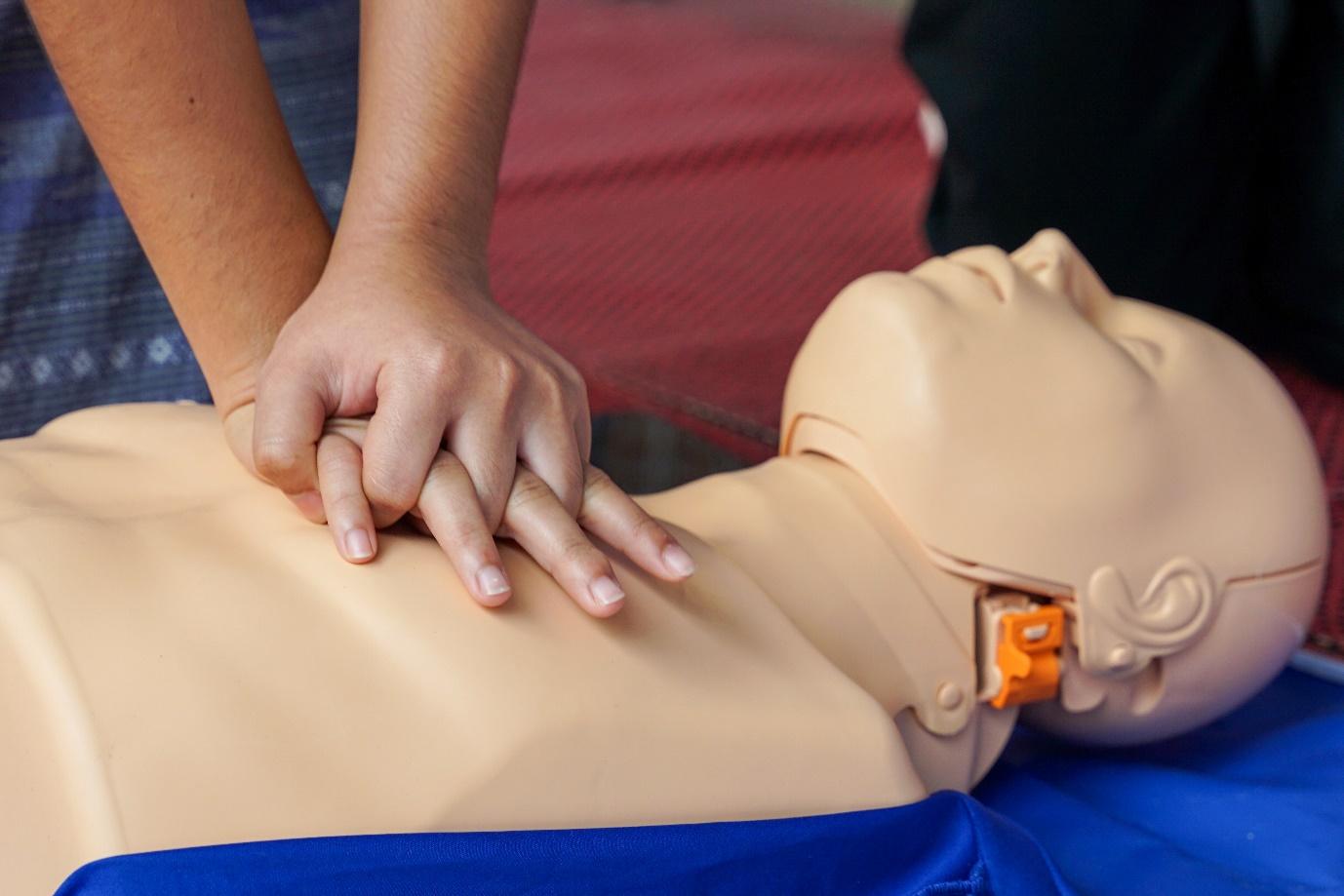 A person practicing cpr on a mannequinDescription automatically generated