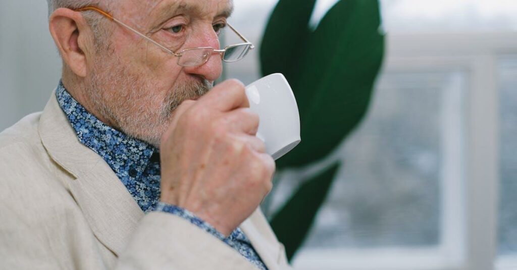 Senior man with eyeglasses enjoying a coffee indoors, conveying a sense of leisure and tranquility.